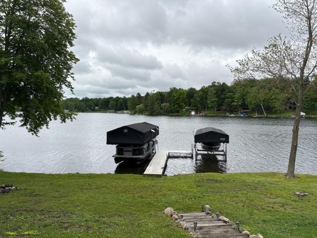 2029 Richardson Ct, Georgetown Twp, WI 54853 - dock with boat lift, a water view, a yard, and a wooded view