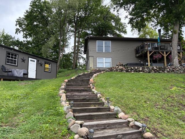 2029 Richardson Ct, Georgetown Twp, WI 54853 - view of front facade with stairs, a front lawn, and a wooden deck