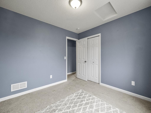 9185 Golden Pond Ln N, Monticello, MN 55362 - unfurnished bedroom featuring attic access, carpet, a textured ceiling, and a closet