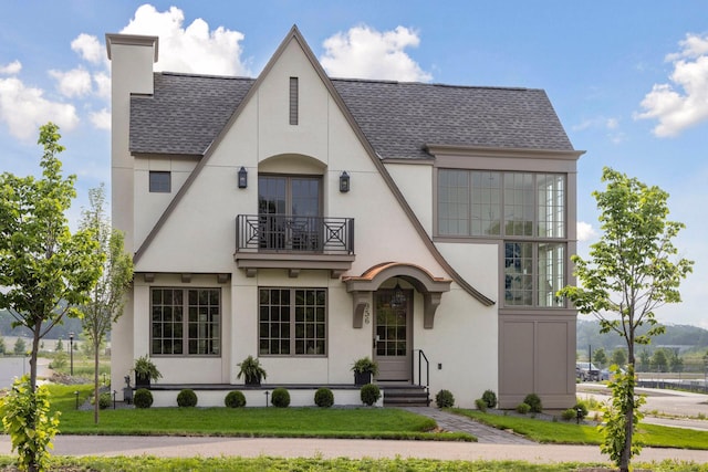 956 Mississippi River Blvd S, Saint Paul, MN 55116 - tudor house with a balcony, a shingled roof, stucco siding, and a chimney