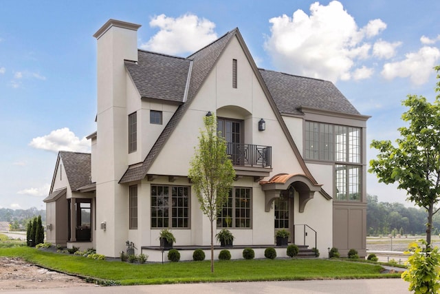 956 Mississippi River Blvd S, Saint Paul, MN 55116 - view of front of property featuring a balcony, a shingled roof, stucco siding, a front lawn, and a chimney
