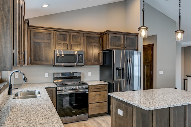 893 Grant St, Ellsworth, WI 54011 - kitchen featuring stainless steel appliances, dark brown cabinets, high vaulted ceiling, light wood-style floors, and hanging light fixtures