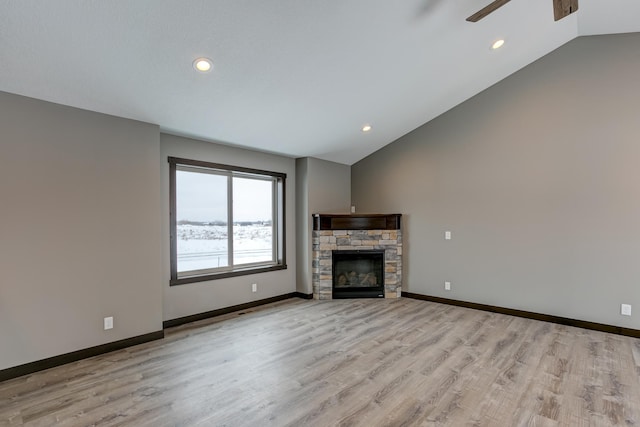 893 Grant St, Ellsworth, WI 54011 - unfurnished living room featuring vaulted ceiling, ceiling fan, light wood-style floors, a fireplace, and recessed lighting