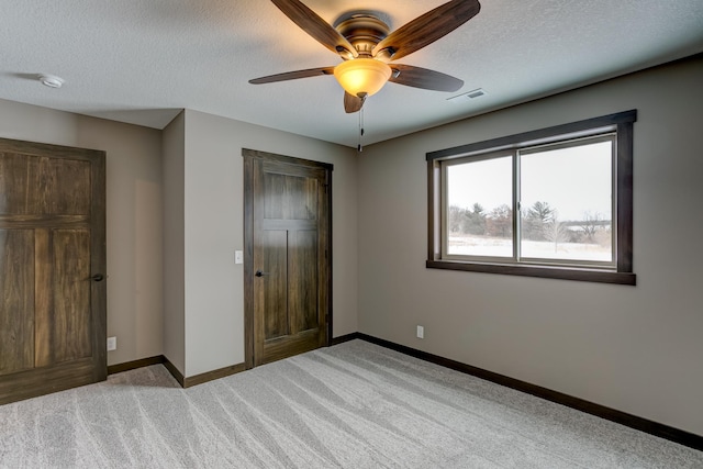 893 Grant St, Ellsworth, WI 54011 - unfurnished bedroom featuring light carpet, a textured ceiling, and ceiling fan
