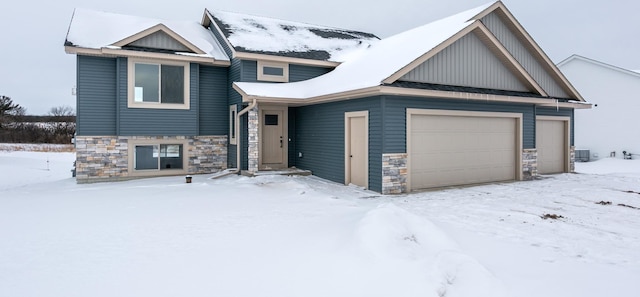 893 Grant St, Ellsworth, WI 54011 - view of front facade with stone siding, an attached garage, and board and batten siding