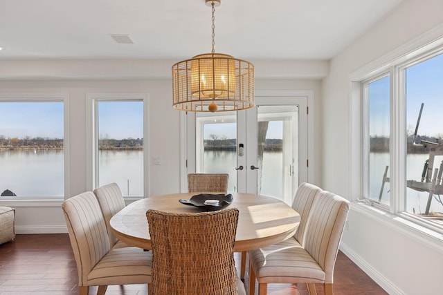 2807 Mckenzie Point Rd, Minnetonka, MN 55391 - dining room with wood finished floors, a chandelier, and a water view