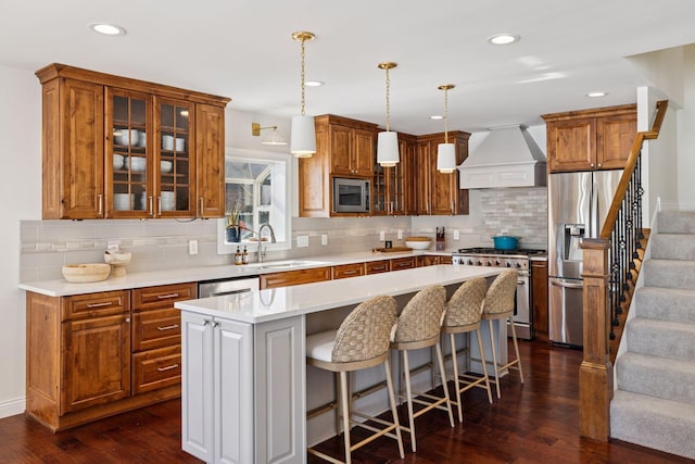 2807 Mckenzie Point Rd, Minnetonka, MN 55391 - kitchen with custom exhaust hood, stainless steel appliances, decorative backsplash, glass insert cabinets, and a center island