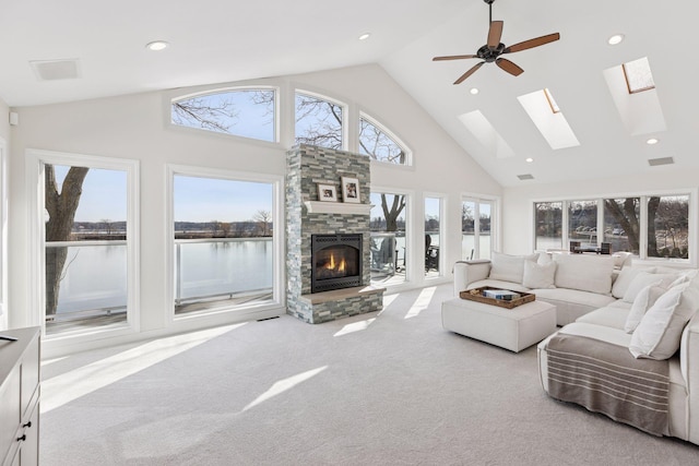 2807 Mckenzie Point Rd, Minnetonka, MN 55391 - carpeted living room featuring high vaulted ceiling, a water view, healthy amount of natural light, a stone fireplace, and recessed lighting