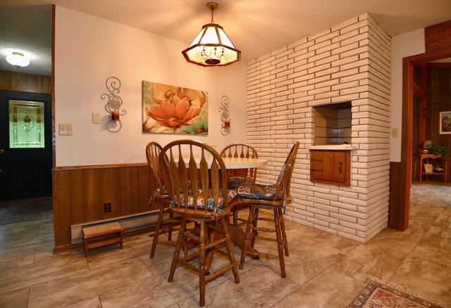 22761 105th Ave, Milaca, MN 56353 - dining room with wooden walls, wainscoting, a textured ceiling, and brick wall