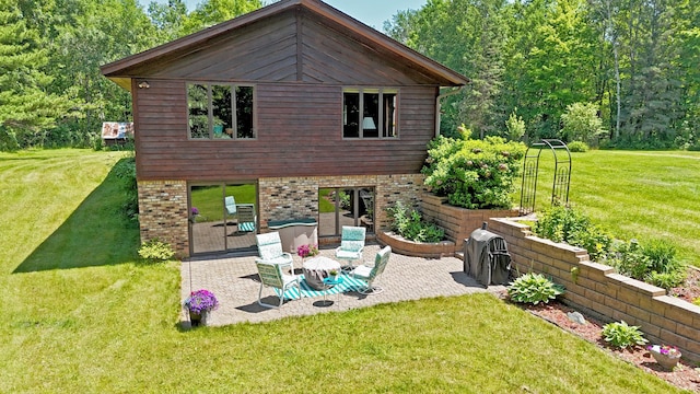 22761 105th Ave, Milaca, MN 56353 - rear view of house with a patio area, a lawn, and brick siding