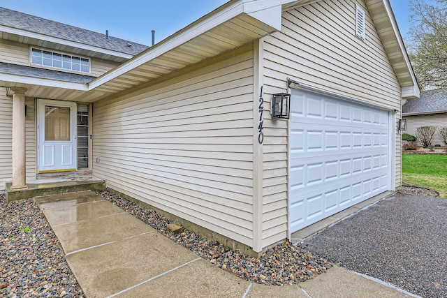 12740 Eveleth Path, Apple Valley, MN 55124 - doorway to property featuring a garage, asphalt driveway, and roof with shingles