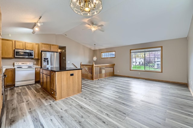 12740 Eveleth Path, Apple Valley, MN 55124 - kitchen featuring stainless steel appliances, lofted ceiling, light wood finished floors, a kitchen island, and rail lighting