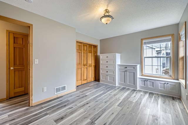 12740 Eveleth Path, Apple Valley, MN 55124 - unfurnished bedroom featuring a textured ceiling, light wood-type flooring, and a closet