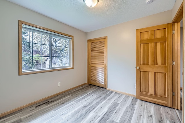 12740 Eveleth Path, Apple Valley, MN 55124 - unfurnished bedroom with a closet, light wood-style floors, and a textured ceiling