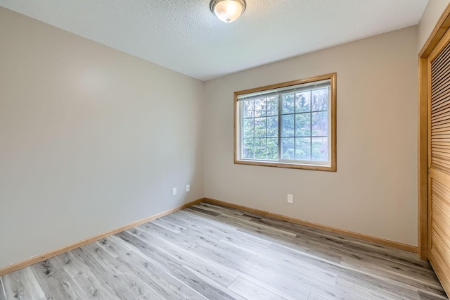 12740 Eveleth Path, Apple Valley, MN 55124 - unfurnished bedroom featuring light wood-style floors, a closet, and a textured ceiling