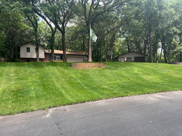 13301 Oak Ridge Rd, Zimmerman, MN 55398 - view of grassy yard with a detached garage and view of scattered trees