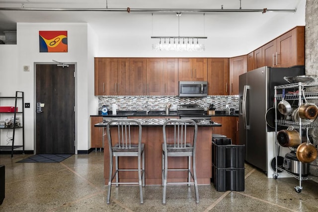 350 Saint Peter St Unit 707, Saint Paul, MN 55102 - kitchen featuring light aggregate flooring, tasteful backsplash, dark countertops, appliances with stainless steel finishes, and a kitchen breakfast bar