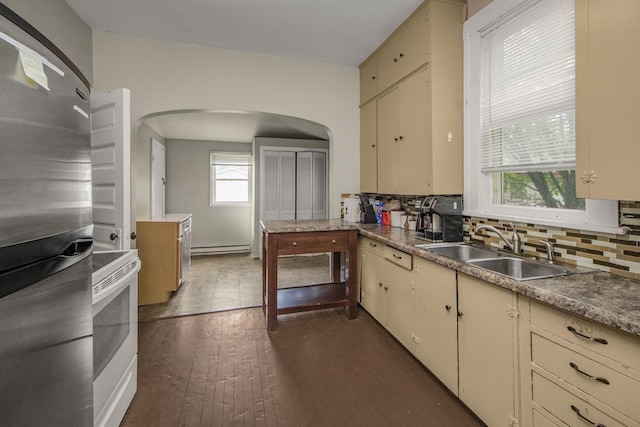 310 4th Ave SW, Hutchinson, MN 55350 - kitchen featuring freestanding refrigerator, white electric stove, arched walkways, and cream cabinets