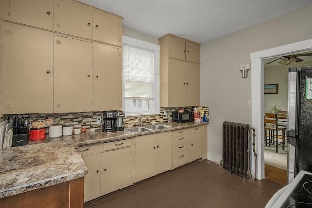 310 4th Ave SW, Hutchinson, MN 55350 - kitchen with radiator, cream cabinets, black microwave, and tasteful backsplash