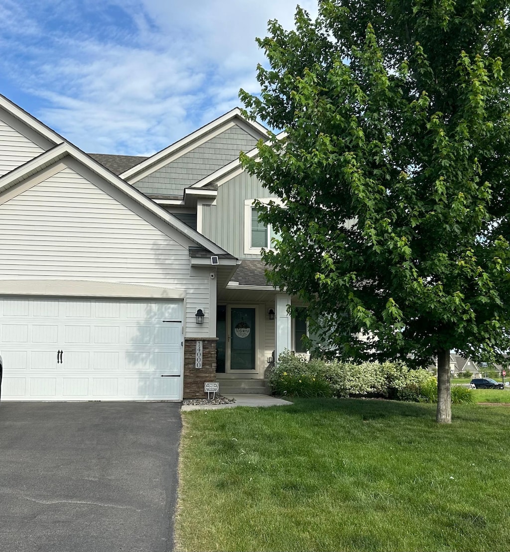 14000 Ashford Path, Rosemount, MN 55068 - view of front facade with a front lawn, driveway, an attached garage, and board and batten siding