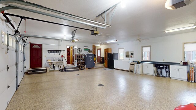 2017 Highland Ave, Albert Lea, MN 56007 - garage featuring a garage door opener, freestanding refrigerator, and a ceiling fan