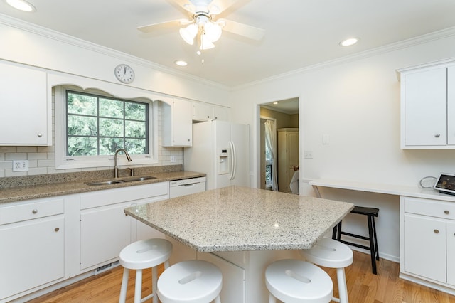 625 Folwell Ln SW, Rochester, MN 55902 - kitchen featuring white appliances, a kitchen bar, light wood-type flooring, backsplash, and ornamental molding