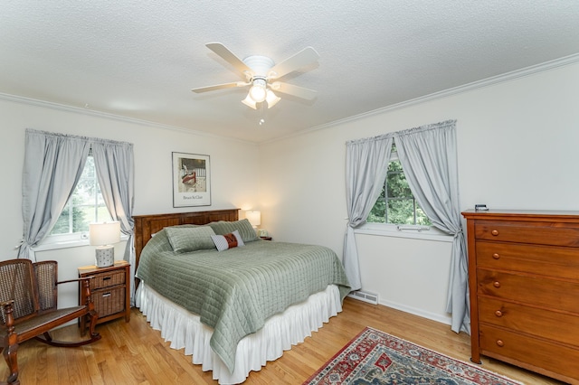 625 Folwell Ln SW, Rochester, MN 55902 - bedroom with crown molding, multiple windows, light wood-type flooring, a textured ceiling, and ceiling fan