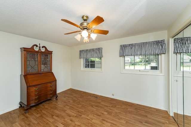 625 Folwell Ln SW, Rochester, MN 55902 - spare room with light wood-type flooring, healthy amount of natural light, a ceiling fan, and a textured ceiling