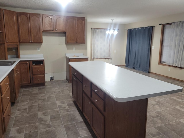 302 3rd St W, Hastings, MN 55033 - kitchen with light countertops, a kitchen island, brown cabinets, and hanging light fixtures