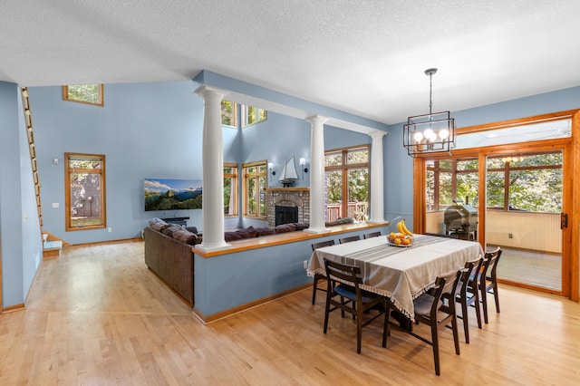 6354 Oxbow Bnd, Chanhassen, MN 55317 - dining space with decorative columns, light wood-style flooring, and a textured ceiling