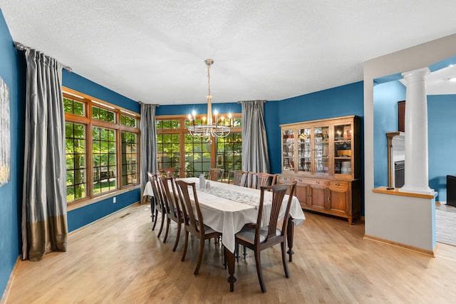 6354 Oxbow Bnd, Chanhassen, MN 55317 - dining room featuring a chandelier, light wood finished floors, decorative columns, and a textured ceiling