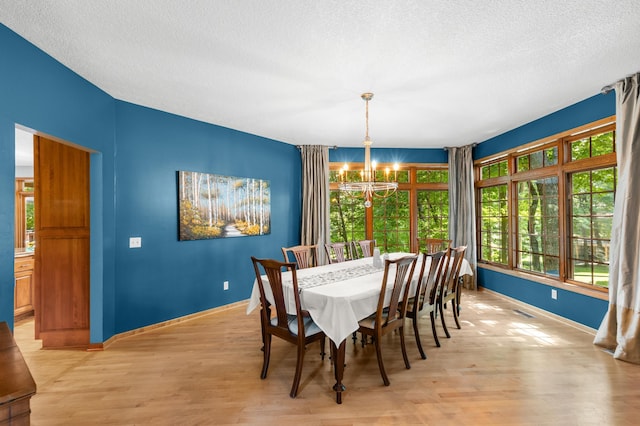6354 Oxbow Bnd, Chanhassen, MN 55317 - dining space with a chandelier, light wood finished floors, and a textured ceiling