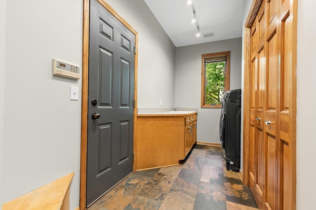 6354 Oxbow Bnd, Chanhassen, MN 55317 - doorway featuring dark stone finish flooring, washer / dryer, and rail lighting