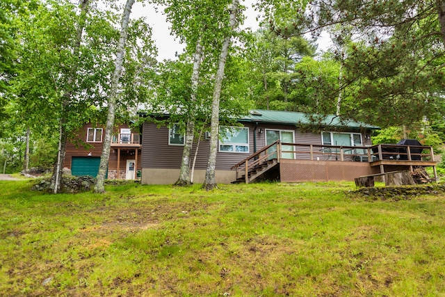 3071 Black Bay Rd, Beatty Twp, MN 55723 - back of house with a wooden deck, an attached garage, a lawn, and a metal roof
