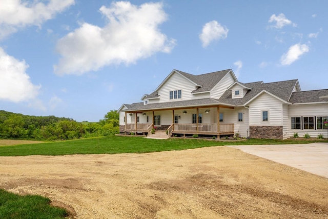 13827 Halstad Ave, Lonsdale, MN 55046 - farmhouse inspired home with roof with shingles, covered porch, a front yard, and stone siding