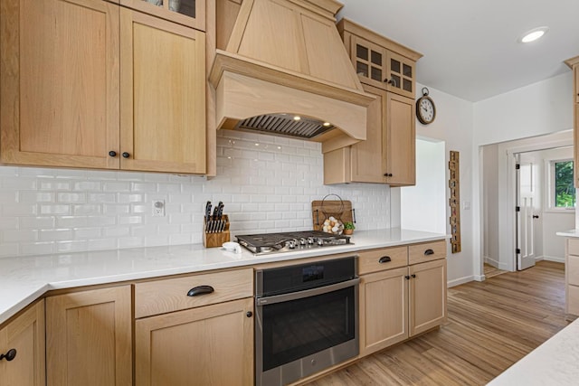 13827 Halstad Ave, Lonsdale, MN 55046 - kitchen with appliances with stainless steel finishes, custom exhaust hood, light brown cabinetry, and light countertops