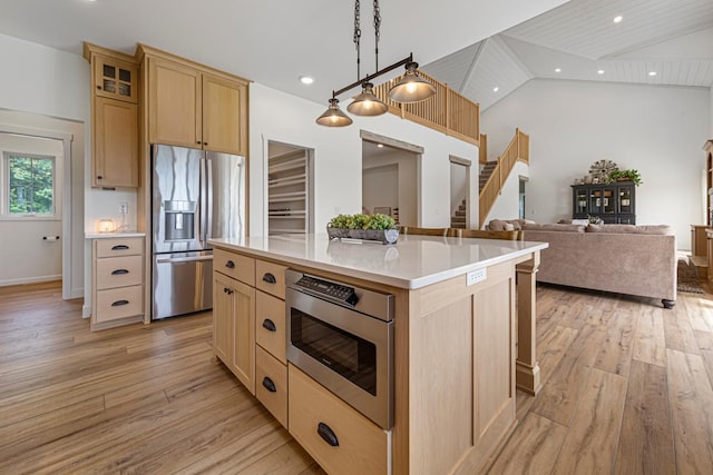 13827 Halstad Ave, Lonsdale, MN 55046 - kitchen featuring appliances with stainless steel finishes, lofted ceiling, light brown cabinetry, light countertops, and light wood-style floors