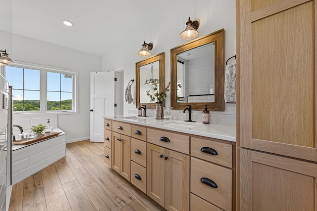 13827 Halstad Ave, Lonsdale, MN 55046 - full bath with double vanity, a garden tub, and wood finished floors