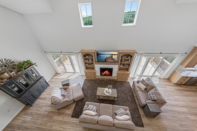 13827 Halstad Ave, Lonsdale, MN 55046 - living area featuring a towering ceiling, wood-type flooring, and a lit fireplace