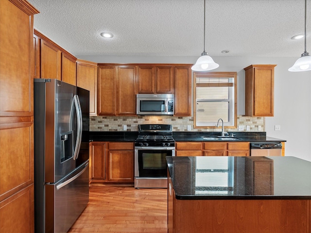 1788 Fescue Ct, Shakopee, MN 55379 - kitchen featuring stainless steel appliances, a textured ceiling, light wood-type flooring, brown cabinetry, and backsplash