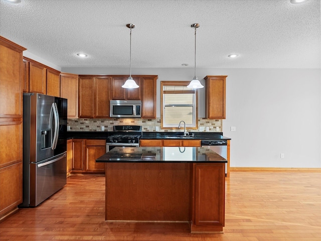 1788 Fescue Ct, Shakopee, MN 55379 - kitchen featuring appliances with stainless steel finishes, light wood-style floors, tasteful backsplash, dark countertops, and a textured ceiling