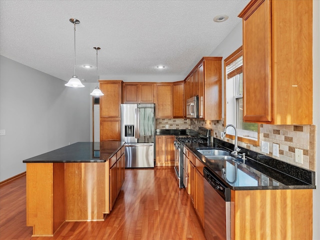 1788 Fescue Ct, Shakopee, MN 55379 - kitchen with stainless steel appliances, wood finished floors, a center island, tasteful backsplash, and brown cabinets