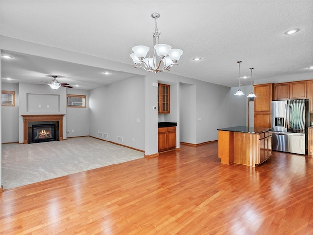 1788 Fescue Ct, Shakopee, MN 55379 - unfurnished living room with light wood-style floors, ceiling fan, a glass covered fireplace, recessed lighting, and a chandelier