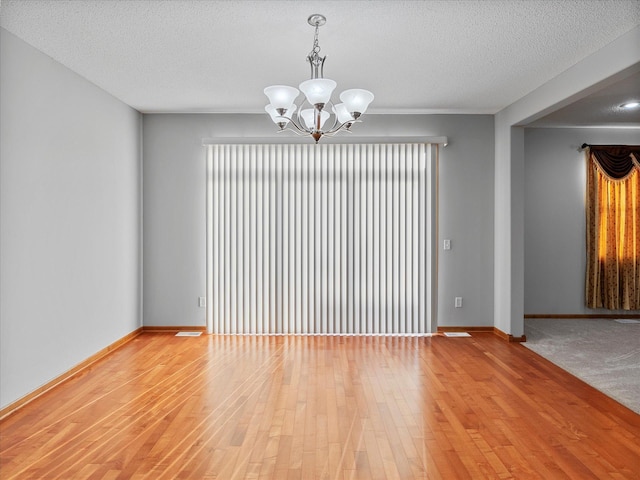 1788 Fescue Ct, Shakopee, MN 55379 - empty room with a chandelier, light wood finished floors, and a textured ceiling