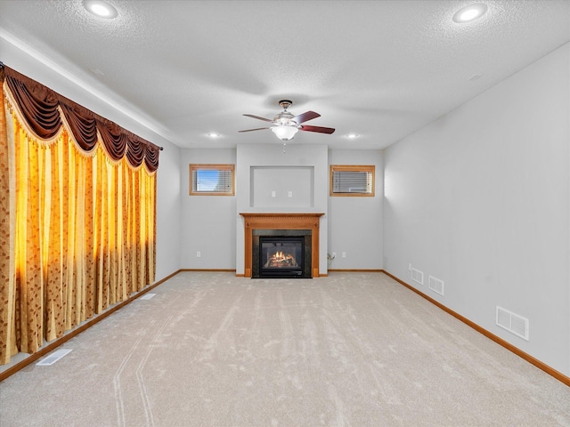 1788 Fescue Ct, Shakopee, MN 55379 - unfurnished living room featuring a fireplace with flush hearth, a ceiling fan, a textured ceiling, carpet, and recessed lighting