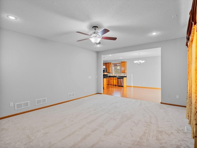 1788 Fescue Ct, Shakopee, MN 55379 - unfurnished living room featuring light colored carpet, a chandelier, ceiling fan, a textured ceiling, and recessed lighting