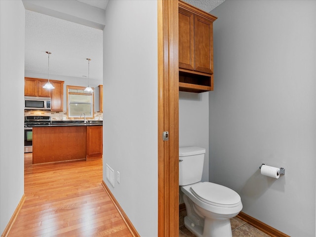 1788 Fescue Ct, Shakopee, MN 55379 - bathroom with decorative backsplash, wood finished floors, vanity, and a textured ceiling