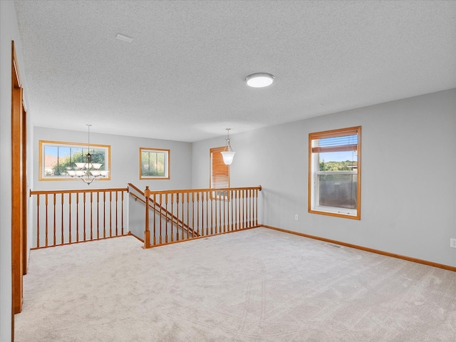 1788 Fescue Ct, Shakopee, MN 55379 - spare room with a chandelier, carpet, a textured ceiling, and healthy amount of natural light