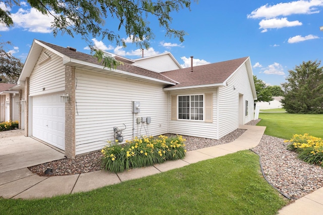 314 Archibald Ln, Dundas, MN 55019 - view of side of property featuring a shingled roof, a garage, a yard, and concrete driveway