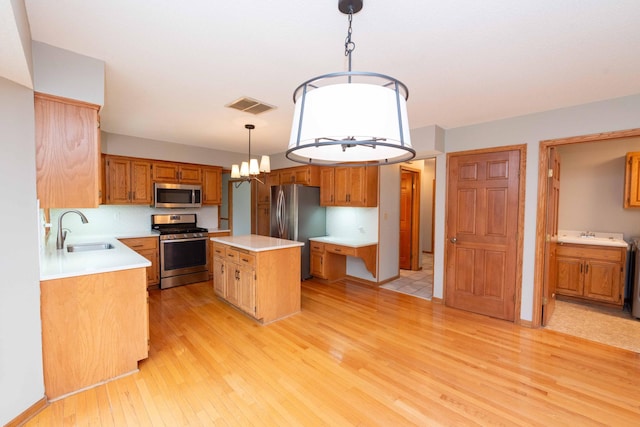 6262 Fernbrook Ln N, Maple Grove, MN 55311 - kitchen featuring stainless steel appliances, light wood-style floors, a kitchen island, light countertops, and brown cabinets